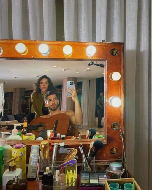 Foto colorida de Bruna Marquezine e João Guilherme. Ele está sem camisa, enquanto a atiz aparece de roupa escura. Eles estão nos bastidores de uma série - Metrópoles