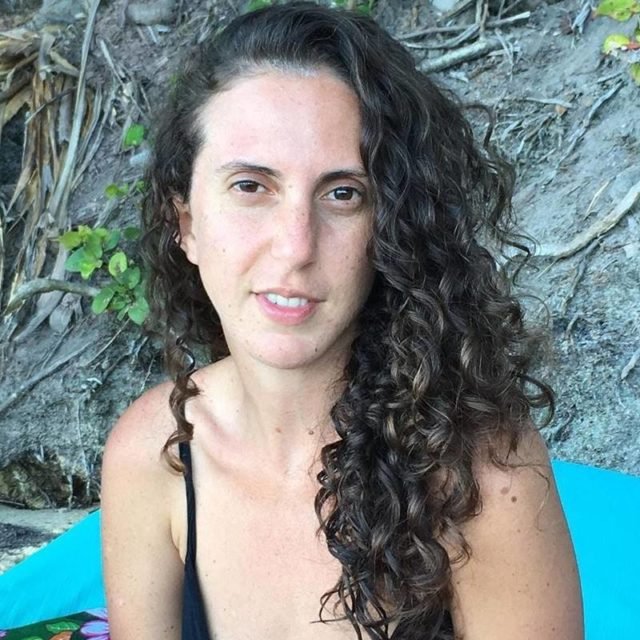 mulher de cabelos cacheados posa séria - metrópoles