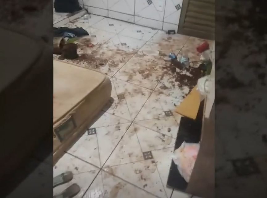 Imagem colorida de um colchão bege no chão. Ao lado do objeto há coisas espalhadas - Metrópoles