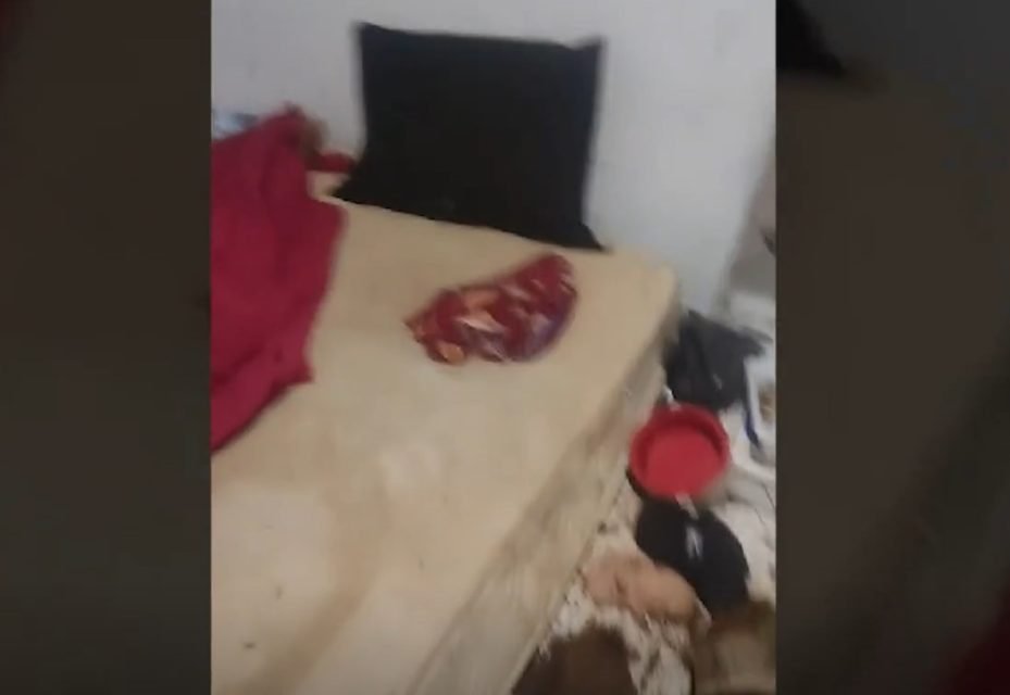 Imagem colorida de um colchão bege no chão. Ao lado do objeto há coisas espalhadas - Metrópoles