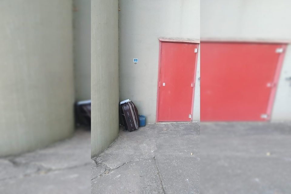 Mala encostada perto de porta vermelha