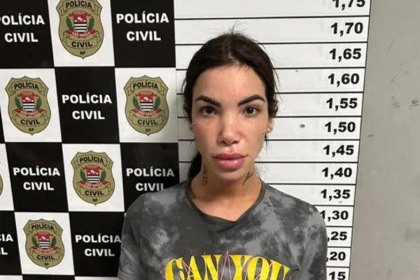 Influencer Vit&oacute;ria Guarizo Demito de cabelo preso em sala da Pol&iacute;cia Civil com marca&ccedil;&atilde;o de altura; ela foi presa por roubar e torturar homem
