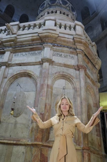 foto colorida de Eliana com roupa bege e as mãos para cima em sentido de oração dentro de uma igreja- metrópoles