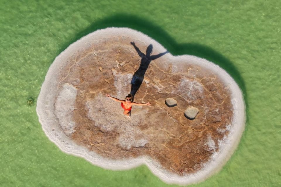 foto colorida de Eliana viista de cima sobre uma pedra de sal no meio do mar - metrópoles