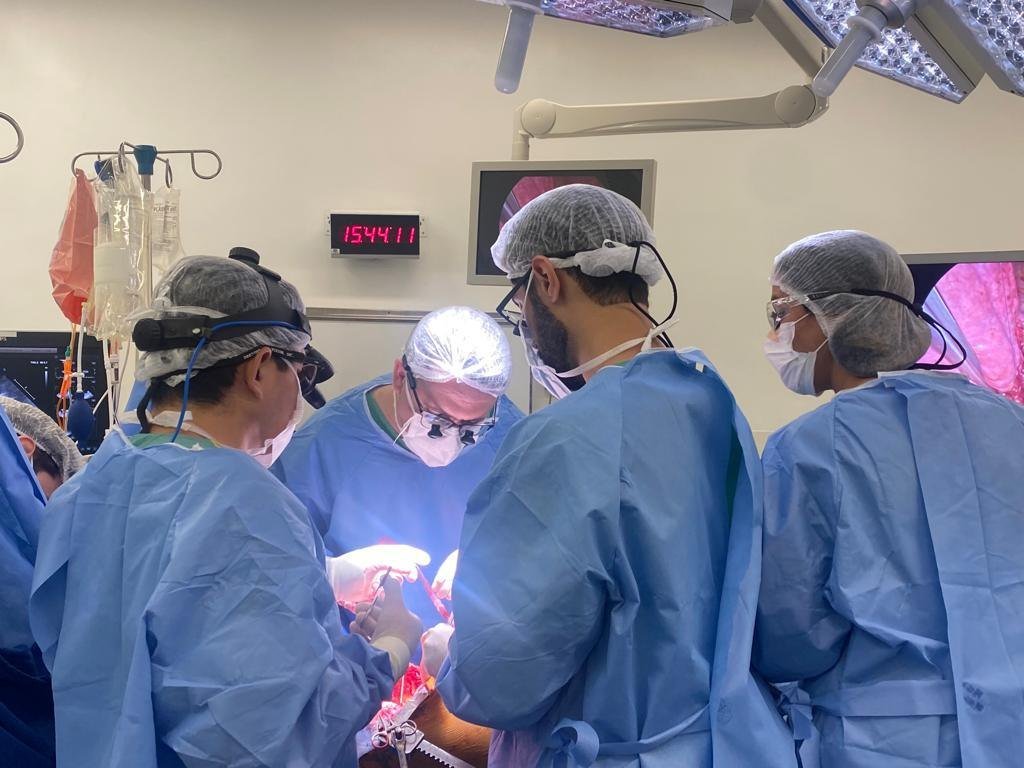 Médicos vestidos com jalecos azuis em mesa de cirurgia no Hospital São Luiz Itaim