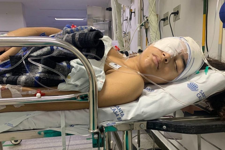 Foto de adolescente deitada em maca de hospital com olho tapado - Metrópoles