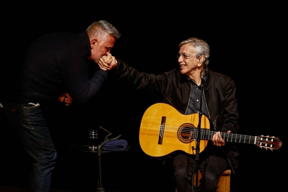 O cantor Orlando Brito beija a mão do Caetano Veloso - metrópoles