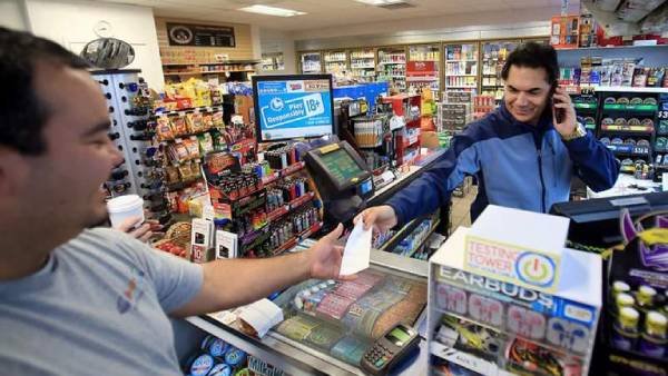 Fotografia colorida mostrando homem fazendo pagando para caixa compras feitas em mercado-Metrópoles