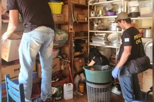 Imagem colorida de policiais periciando local onde o casal mora - Metrópoles