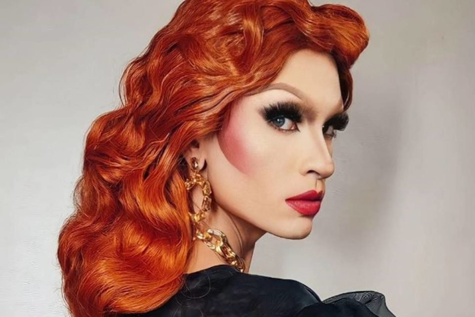 drag queen com peruca ruiva posa de lado - metrópoles