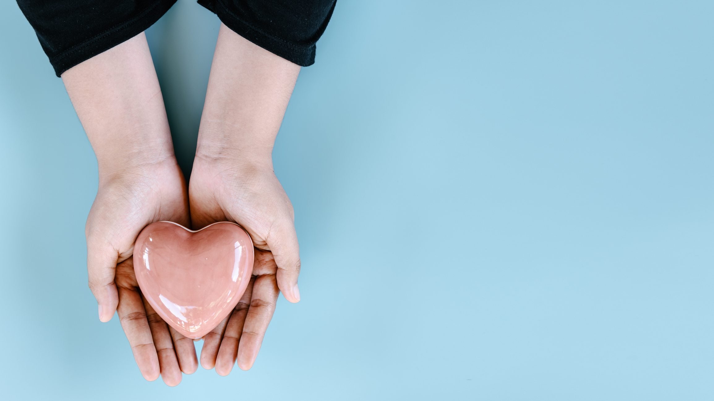 Foto ilustrativa mostra mãos oferecendo um coração de porcelana - doação de órgãos - Metrópoles