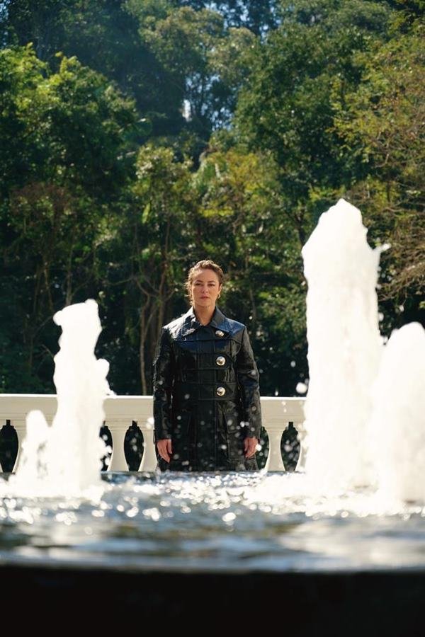 Mulher posando para foto atr&aacute;s de uma fonte de &aacute;gua - Metr&oacute;poles