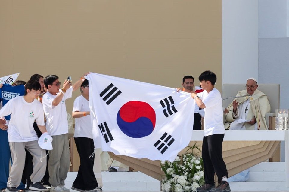 Imagem colorida mostra jovens da Coreia do Sul celebrando junto ao papa Francisco a escolha de Seul como sede da próxima Jornada Mundial da Juventude - Metrópoles