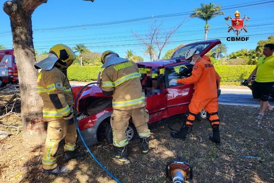 bombeiros tentam remover vítima de carro vermelho
