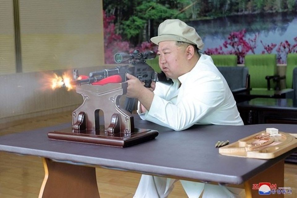 Foto colorida de Kim Jong Un com uma arma - Metrópoles