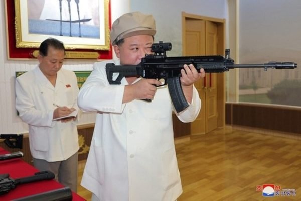 Foto colorida de Kim Jong Un com uma arma - Metrópoles