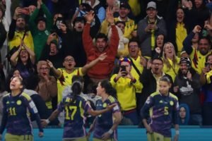 Imagem colorida de torcedores e jogadoras da Colômbia comemorando o gol