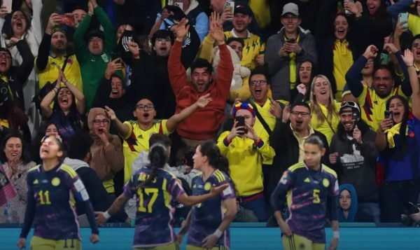 Imagem colorida de torcedores e jogadoras da Colômbia comemorando o gol