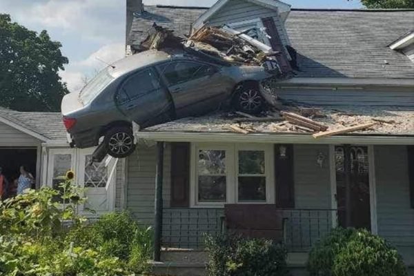 Imagem colorida de carro que colidiu no segundo andar de uma casa nos EUA - Metrópoles