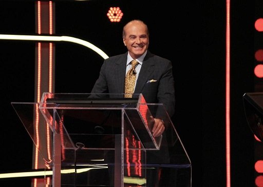 marcelo de carvalho. ele é um homem branco, careca, usa terno e gravata e está na bancada de um programa - Metrópoles