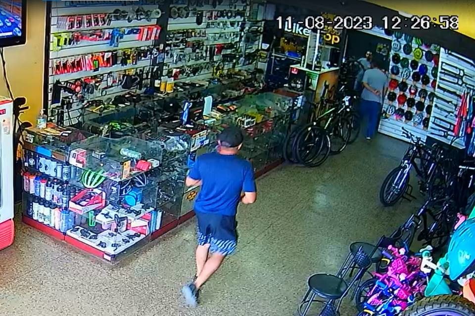 Homem de roupa azul e boné dentro de loja de bicicleta