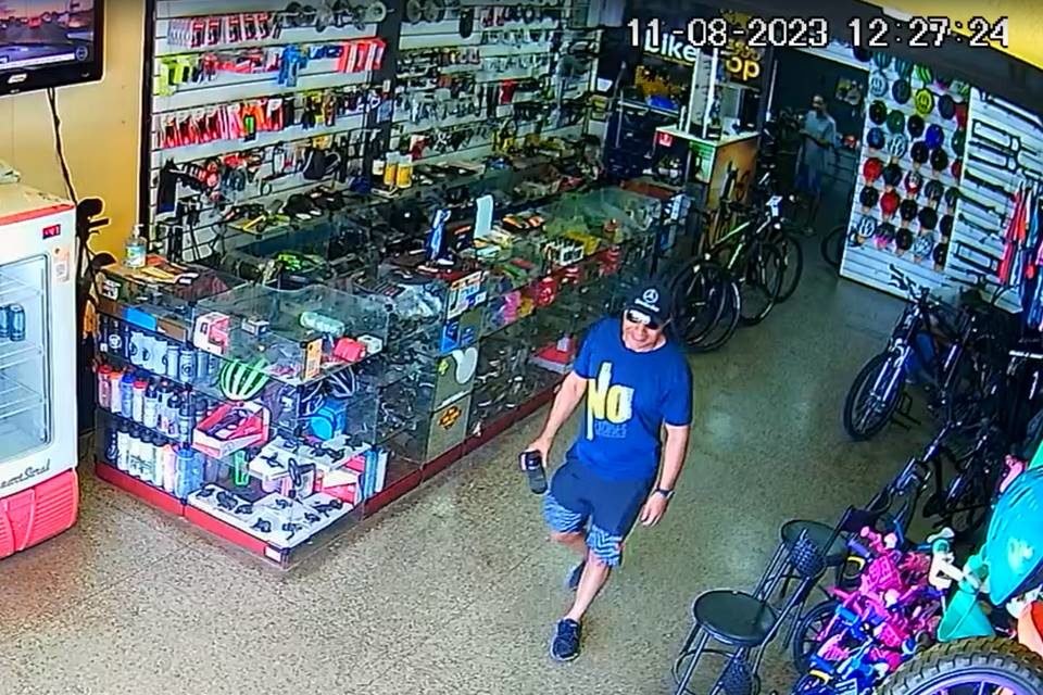 Homem de roupa azul e boné dentro de loja de bicicleta