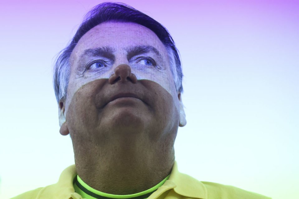 Ex-presidente Jair Bolsonaro (PL) com luz colorida no rosto - Metrópoles