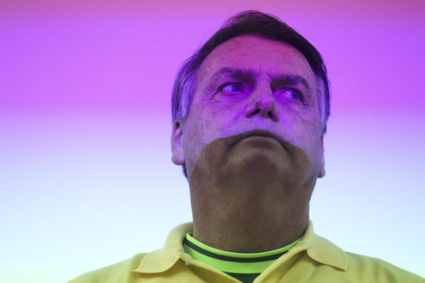 Ex-presidente Jair Bolsonaro (PL) com luz colorida no rosto - Metrópoles