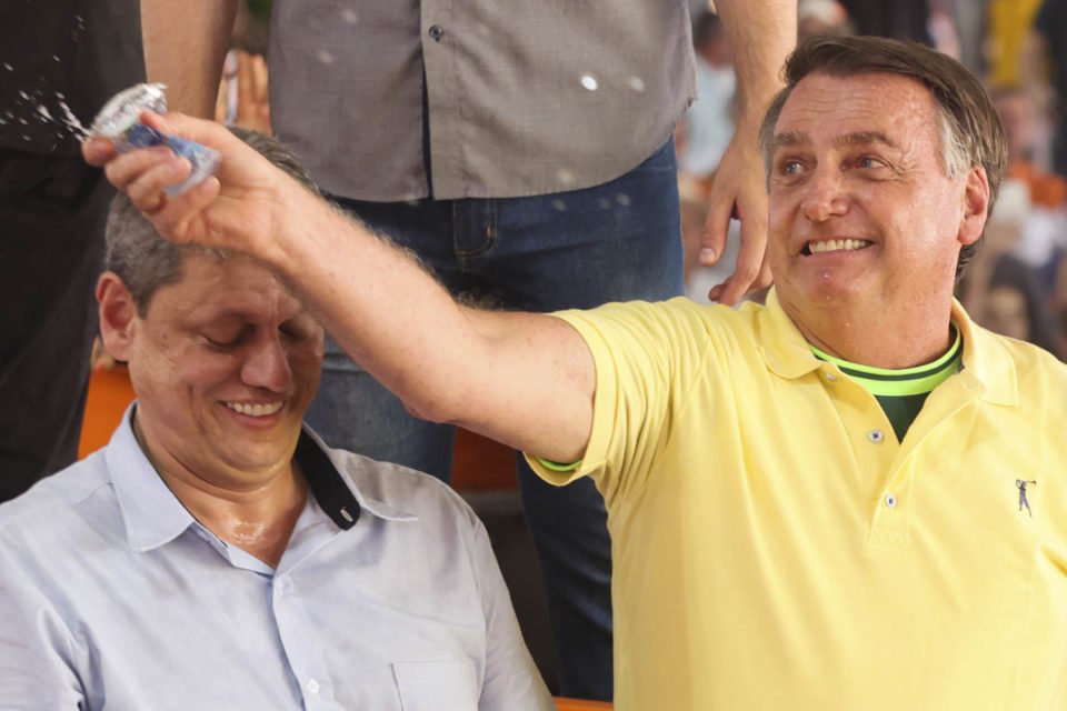 Foto colorida do ex-presidente Jair Bolsonaro de camisa amarela ao lado do governador Tarcísio de Freitas em evento do agronegócio em são paulo - Metrópoles
