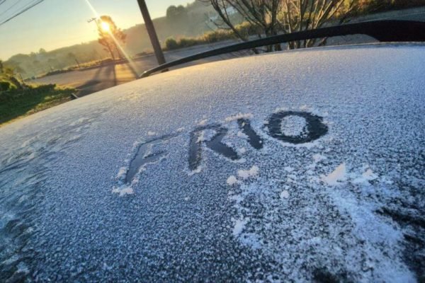 Imagem colorida da palavra "frio" escrita com gelo no capô de um carro - Metrópoles