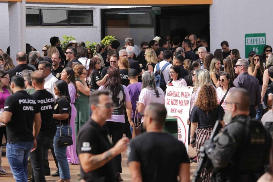 Policiais civis uniformizados participam de velório. Multidão