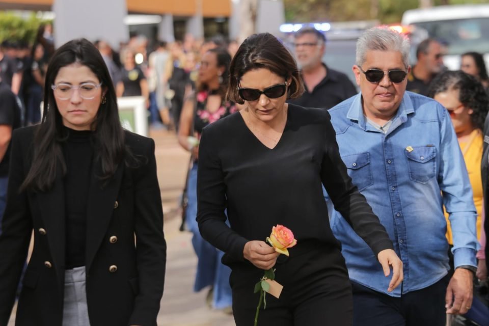 michelle bolsonaro com roupa preta e segurando rosa na mão