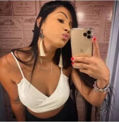 Mulher com cabelo liso preto posando para foto com o celular 