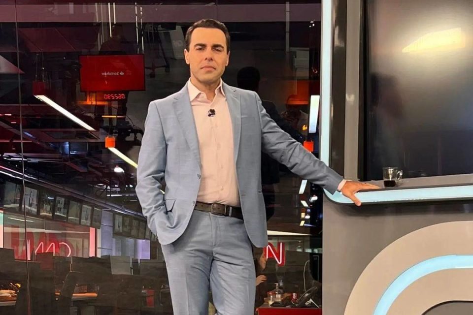 Foto colorida de Rafael Colombo usando terno nos bastidores da CNN Brasil - Metrópoles