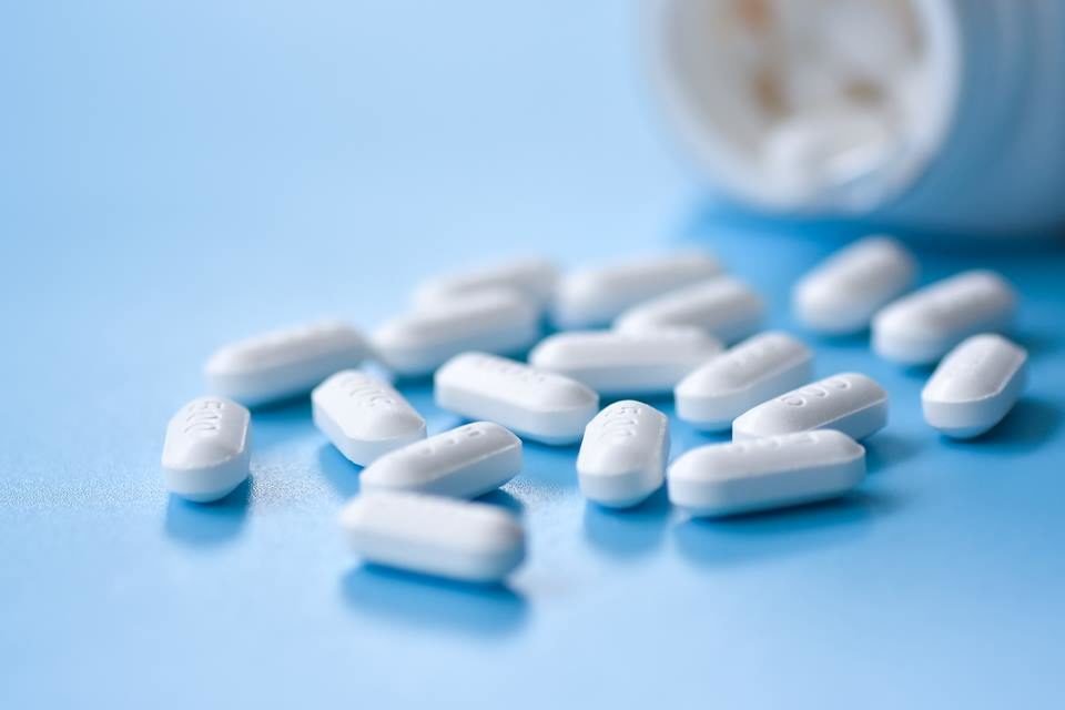 Foto colorida de remédios em uma mesa azul - Metrópoles