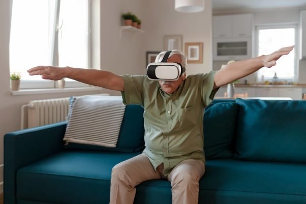 Foto mostra idoso brincando com um óculos de realidade virutal