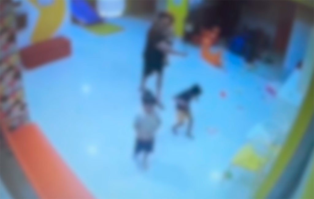 Imagem colorida borrada de cmera de segurana de mulher agredindo criana autista
