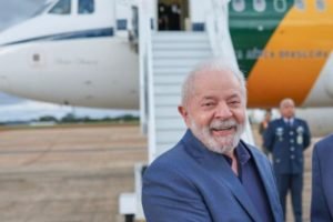 Oposição Em foto colorida, Lula aparece diante do avião presidencial