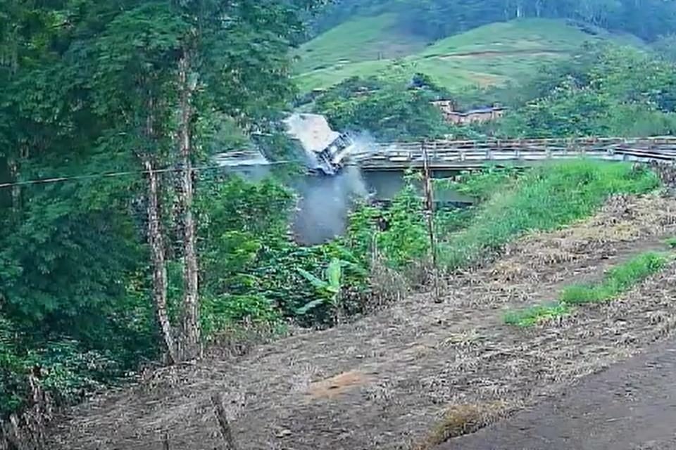 Foto colorida do momento em que o motorista de um caminhão perde o controle do veículo e cai de ponte na BR-101 - Metrópoles