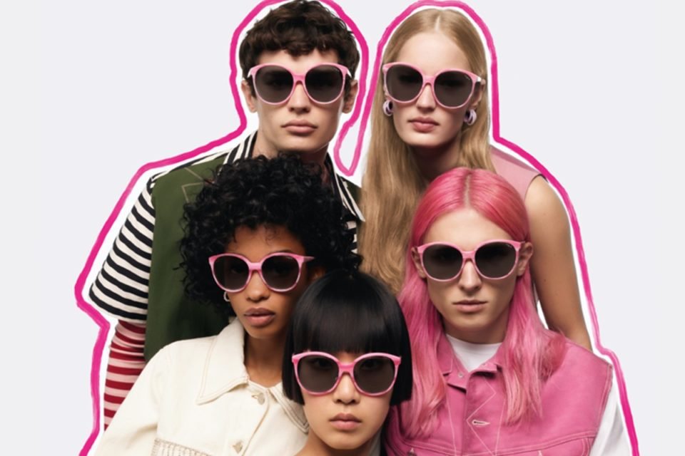Grupo de cinco modelo usando óculos escuros. Na imagem de fundo branco, há uma linha rosa que contorna as pessoas - Metrópoles