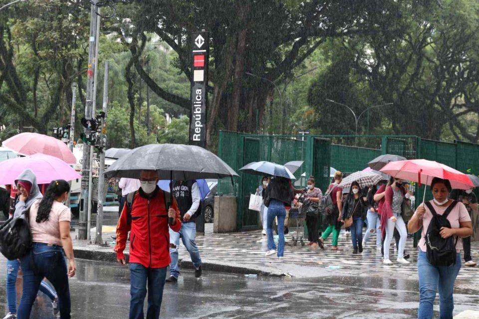 foto colorida de pedestres caminhando com guarda-chuva no centro de São Paulo, perto da estação República - Metrópoles