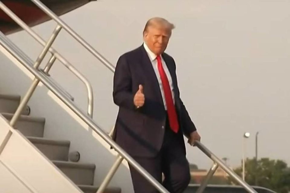 imagem colorida mostra donald trump descendo de avião usando terno preto com gravata vermelha suprema corte michigan - Metrópoles
