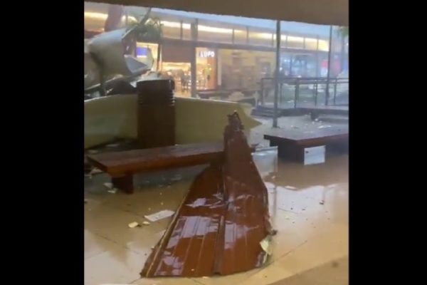 foto colorida de placa da cobertura do shopping Serramar, em Caraguatatuba, caída no chão após ser derrubada pela ventania - Metrópoles