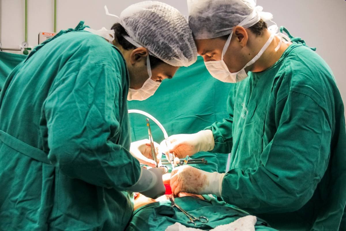 Fotografia colorida mostrando dois médicos fazendo cirurgia-Metrópoles
