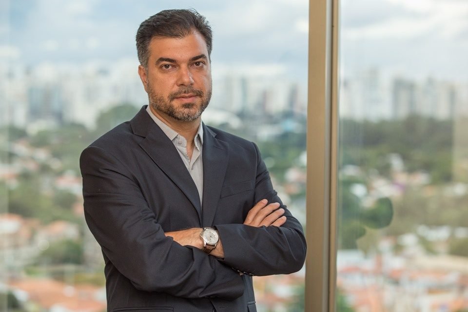 Paulo Gala, economista-chefe do Banco Master, posa para foto. Ele veste um terno escuro sobre uma camisa clara e está de braços cruzados - Metrópoles