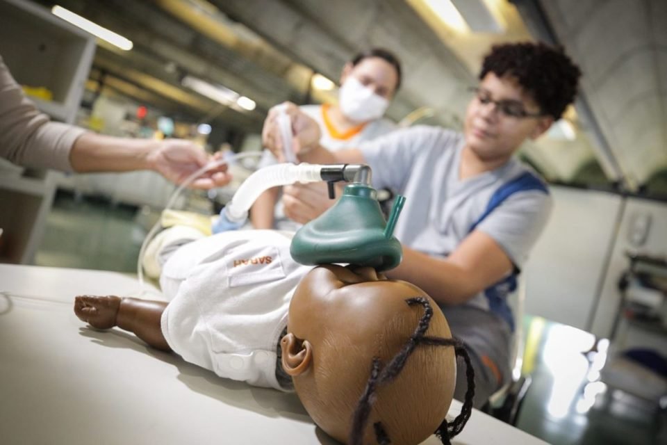 Foto de menino brincando com boneca com respirador - Metrópoles