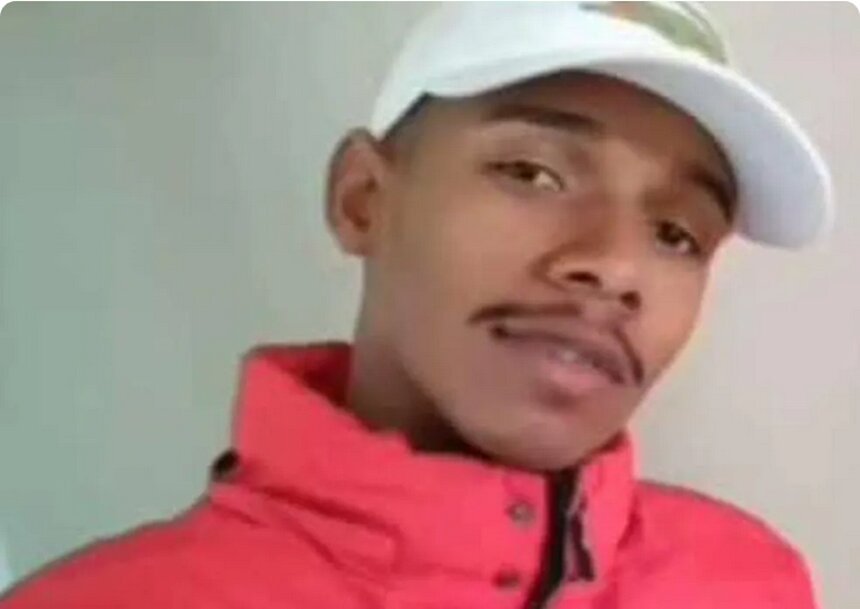 Em foto colorida jovem pardo usa boné branco, blusa de frio rosa escuro e ostenta bigodinho - Metrópoles