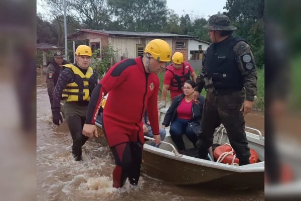 Fotografia colorida de bombeiros do Rio Grande do Sul realizando um salvamento de pessoas alagadas, em Passo Fundo (RS)