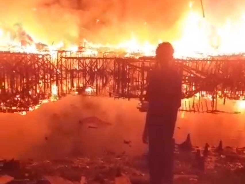 Foto colorida mostra casas pegando fogo em comunidade de Santos