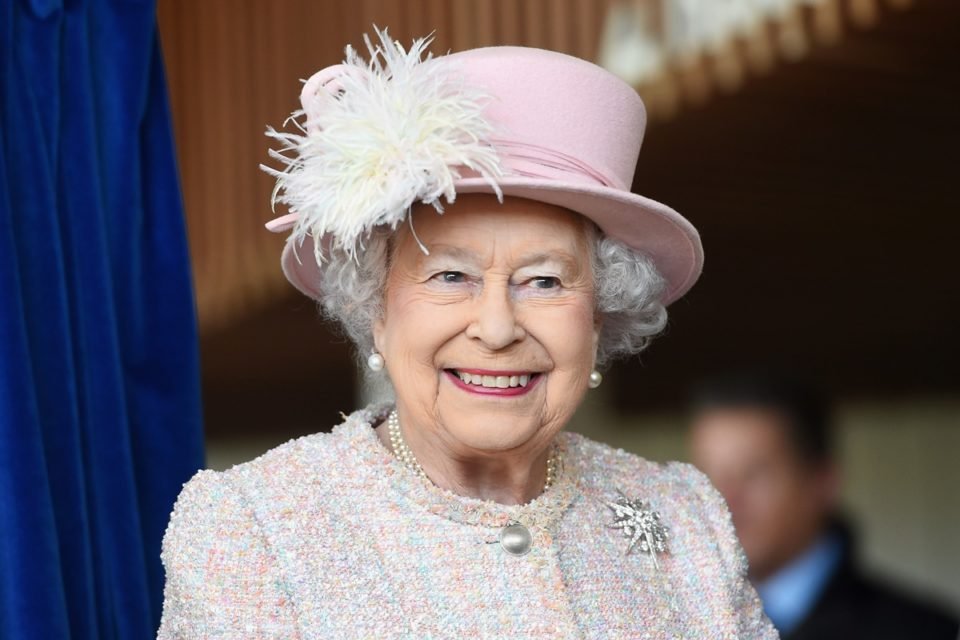 Foto colorida. Imagem mostra a falecidade rainha Elizabeth II, um idosa, branca, vestida com um roupa toda cor-de-rosa clara sorrindo - Metrópoles